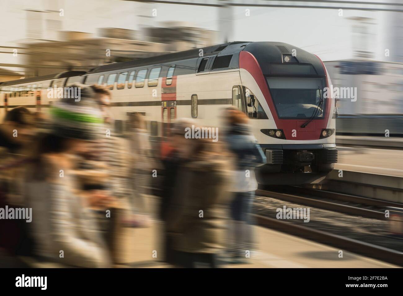 An einem sonnigen Tag zieht der Schnellzug durch den belebten Bahnhof der Stadt Lausanne in der schweiz. Pendler, die auf einen schnellen Zug warten. Stockfoto