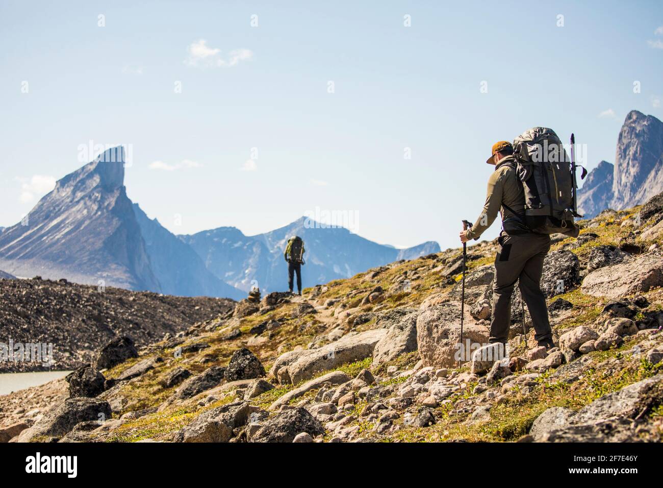 Rucksacktouristen wandern über felsiges Gelände im Akshayak Pass. Stockfoto