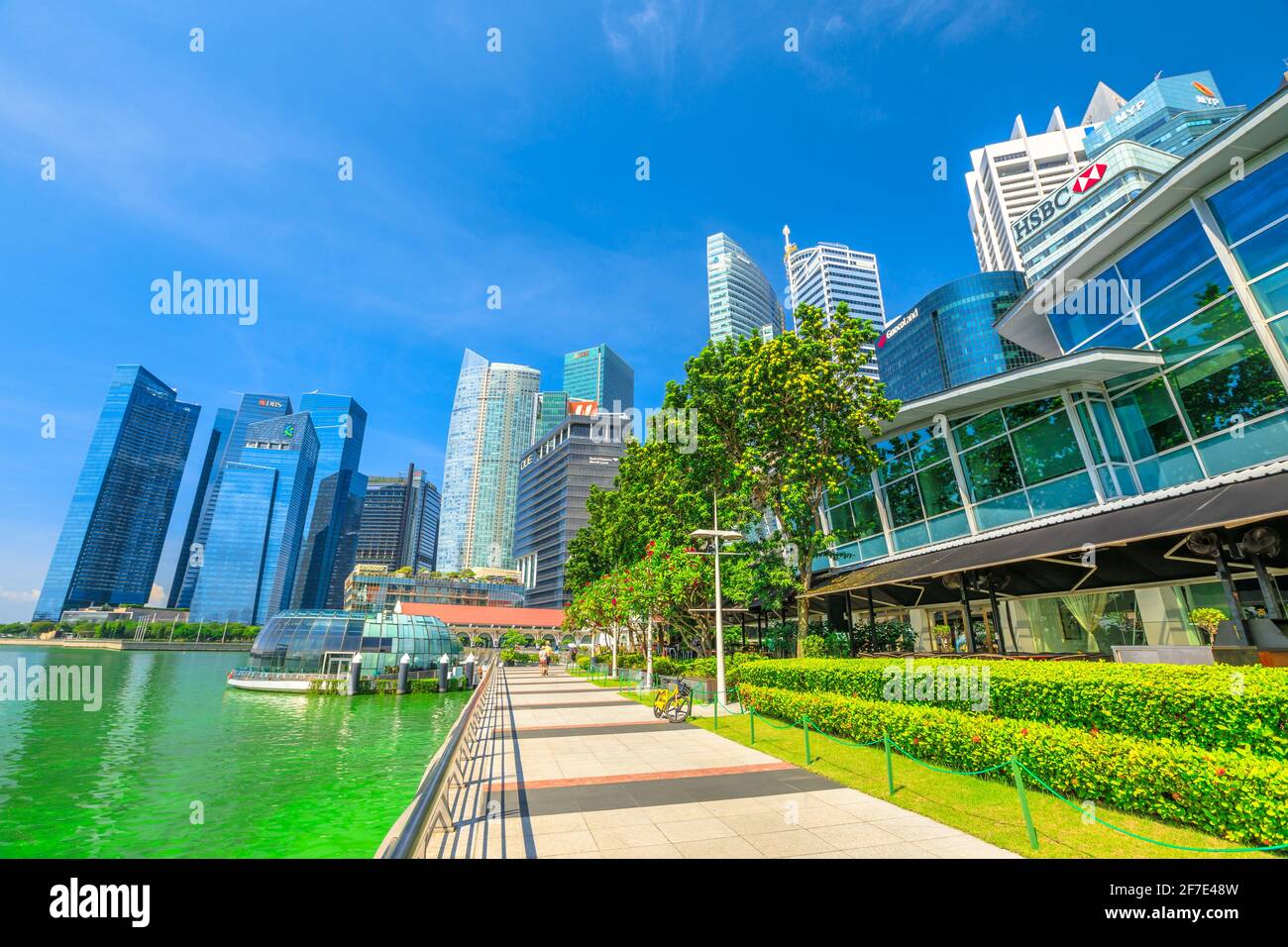 Singapur - 28. April 2018: Die Seepromenade von Marina Bay an einem hellen sonnigen Tag mit blauem Himmel. Central Business District CBD Gebäude und Stockfoto