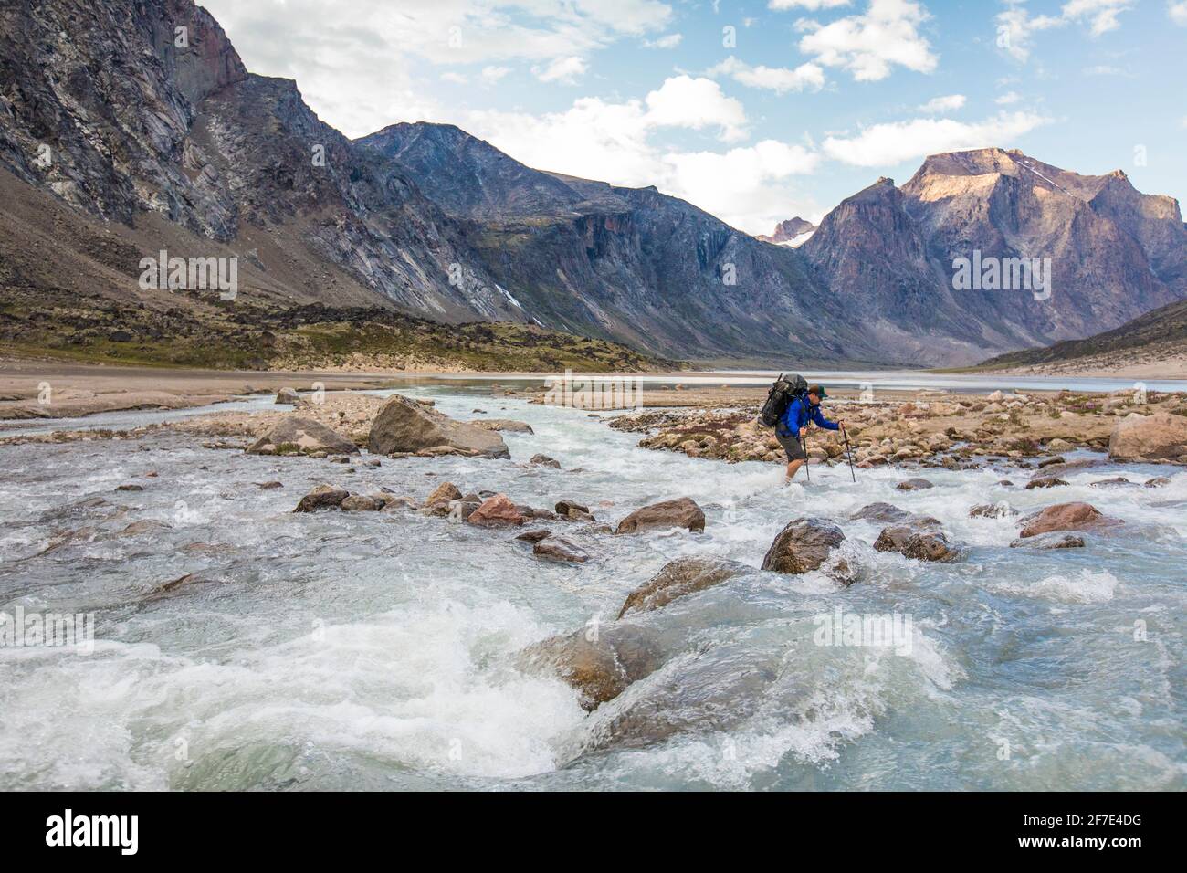 Backpacker durchquert den kalten, rauschenden Fluss auf Baffin Island Stockfoto