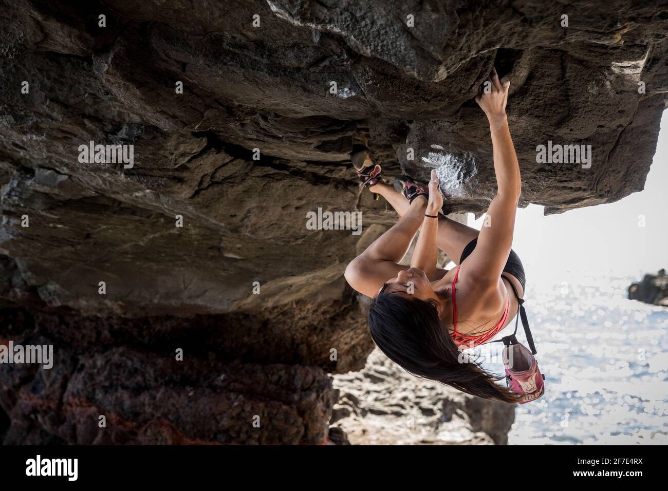 Mutiger Athlet, der mutig an einem riesigen Felsen am hängt Arch Stockfoto