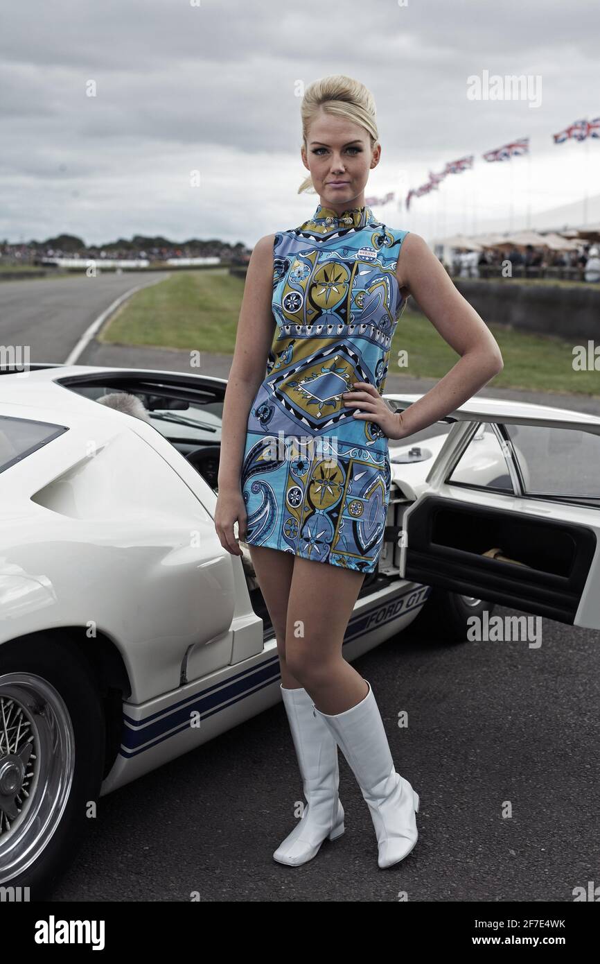GROSSBRITANNIEN / England /Drive Style /Model trägt Minirock und posiert mit Rennwagen beim Goodwood Revival . Stockfoto