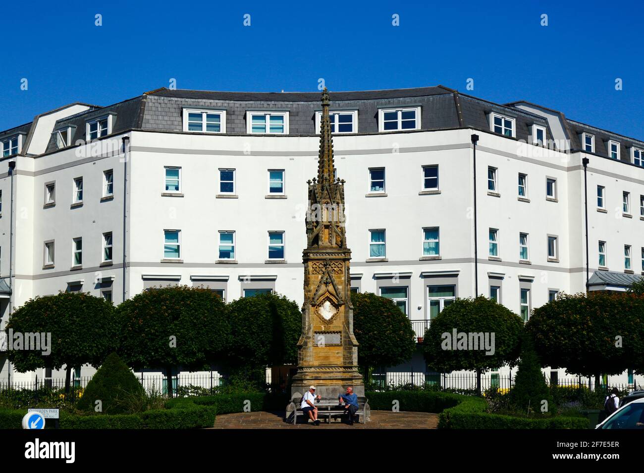 Männer sitzen auf einer Bank vor dem Edward Hoare-Denkmal an der Ecke von Culverden Park und St John's Road, Royal Tunbridge Wells, Kent, England Stockfoto