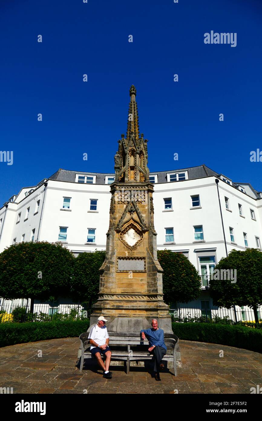 Männer sitzen auf einer Bank vor dem Edward Hoare-Denkmal an der Ecke von Culverden Park und St John's Road, Royal Tunbridge Wells, Kent, England Stockfoto