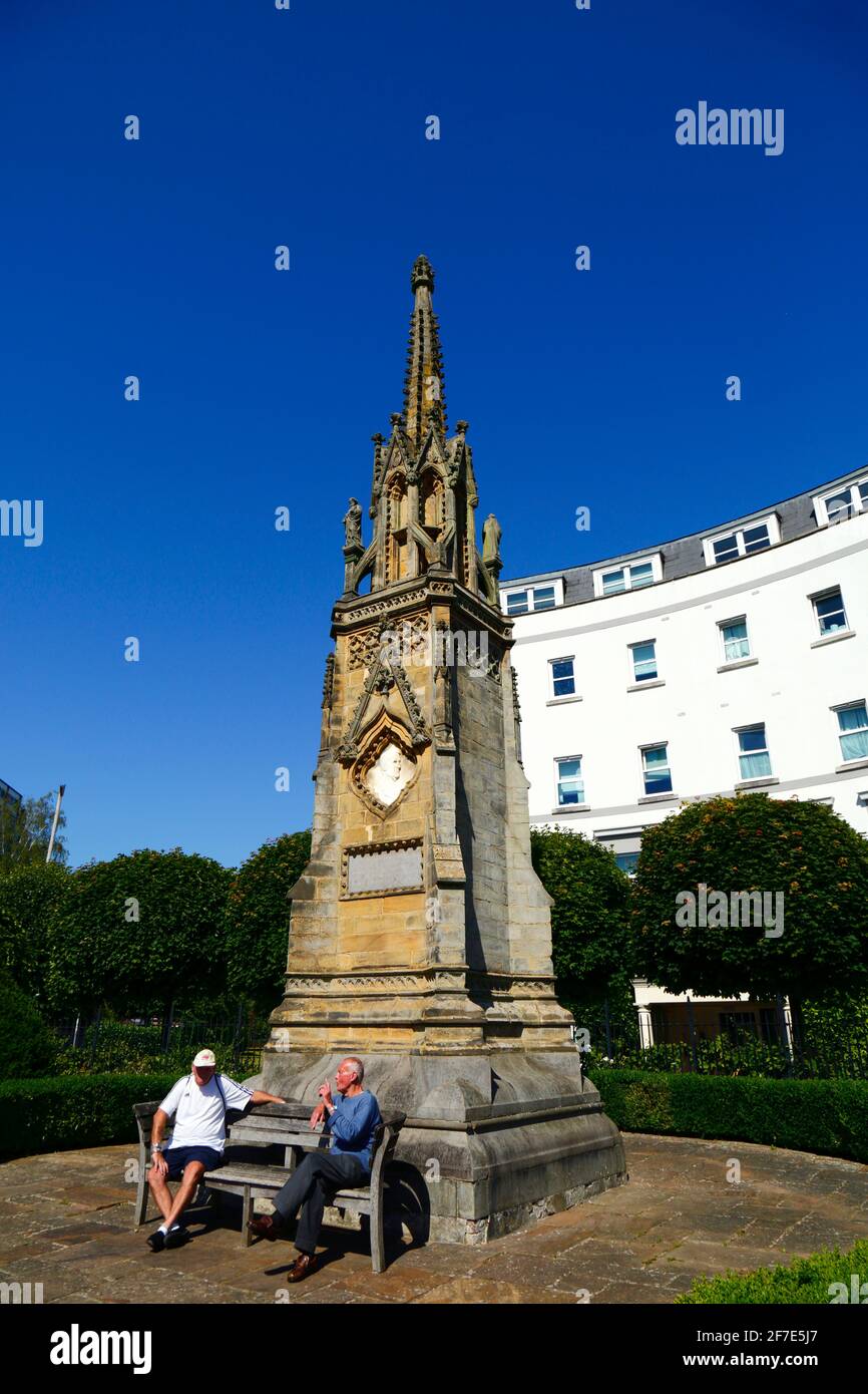 Männer sitzen auf einer Bank vor dem Edward Hoare-Denkmal an der Ecke von Culverden Park und St John's Road, Royal Tunbridge Wells, Kent, England Stockfoto
