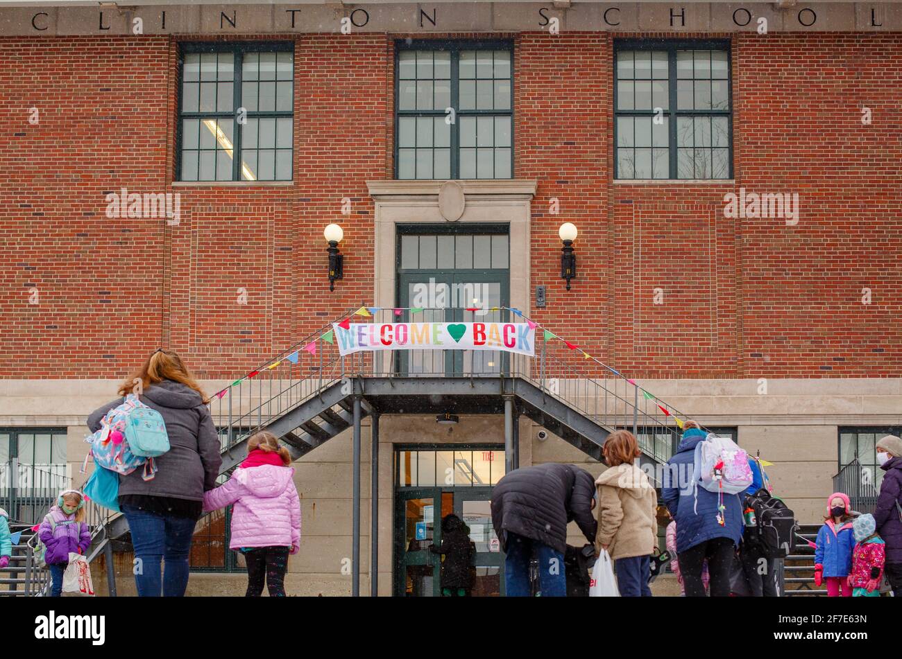 Eltern stehen mit Kindern im Gesicht am Eingang der Schule Masken Stockfoto