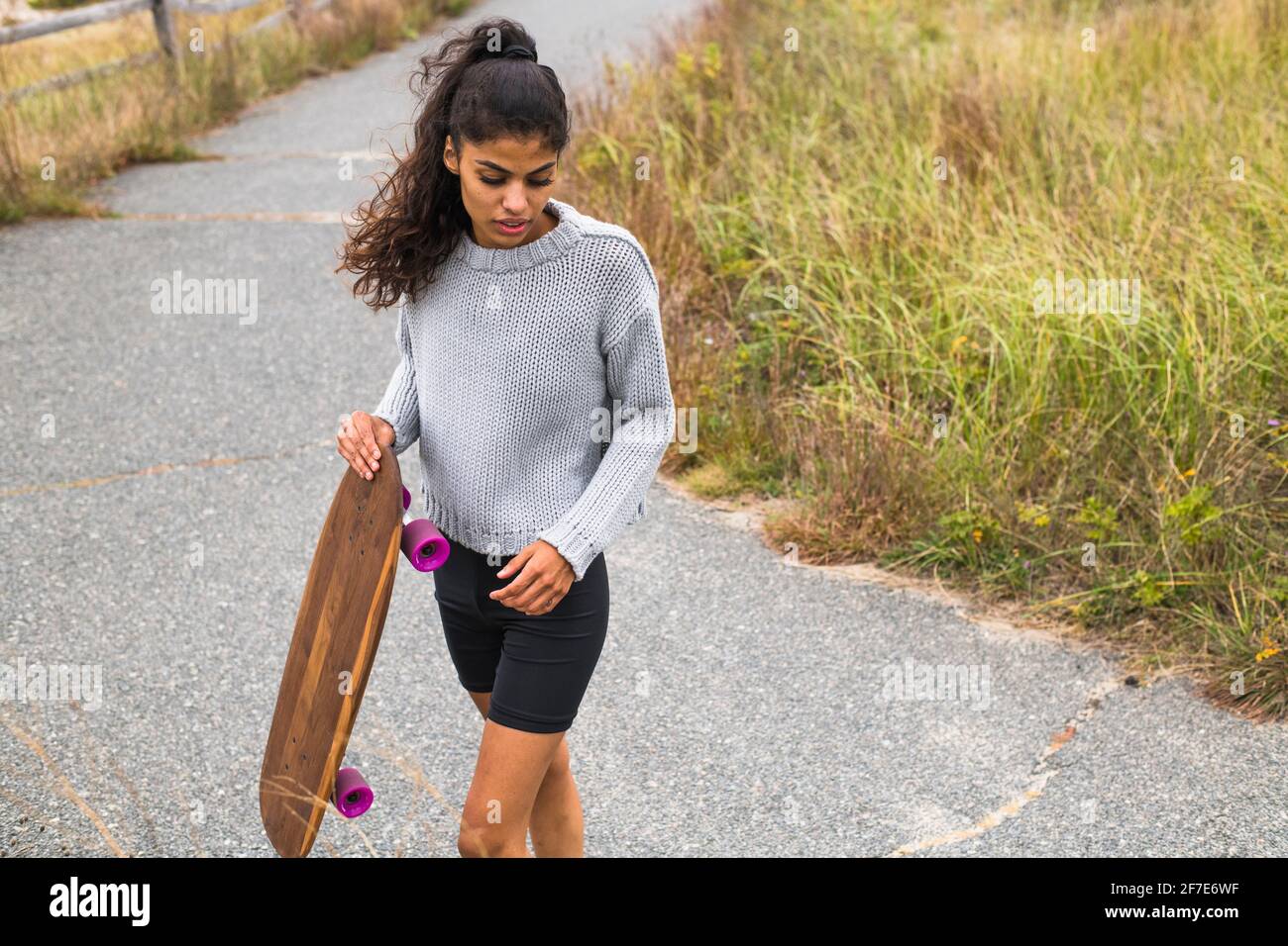 Junge Frau Skateboarding barfuß an bewölktem Tag Stockfoto
