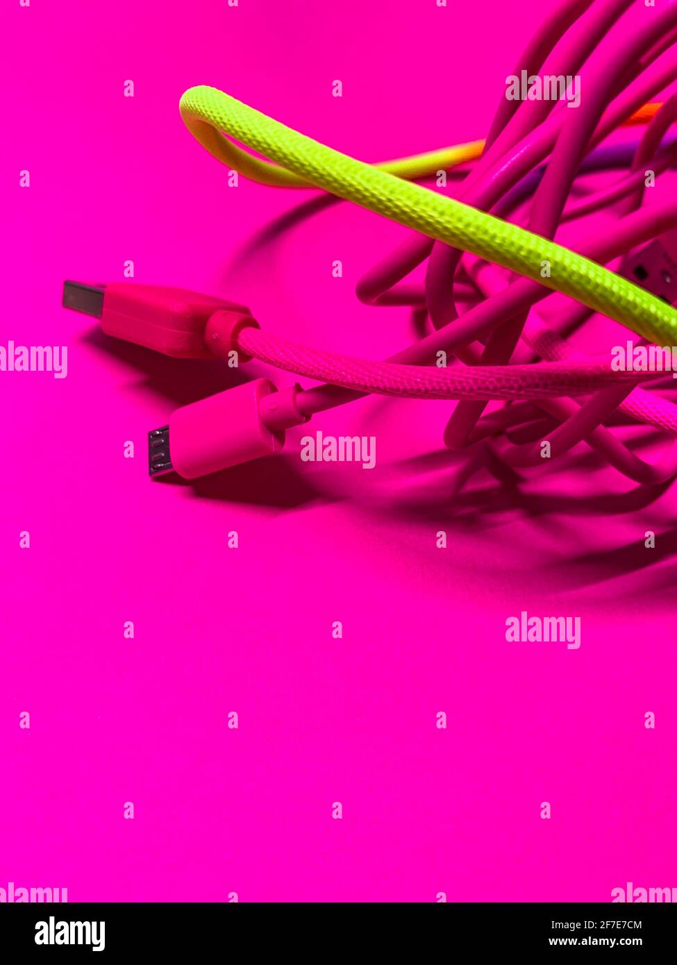 Kabelgewirr usb Kabel rosa neongelb kontrastierenden Farben vertikal Stockfoto