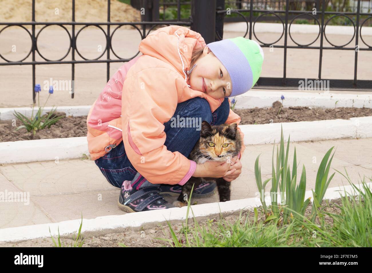 Ein 5-10-jähriges Mädchen fand sie schwarz und orange Katz und umarmt es Stockfoto