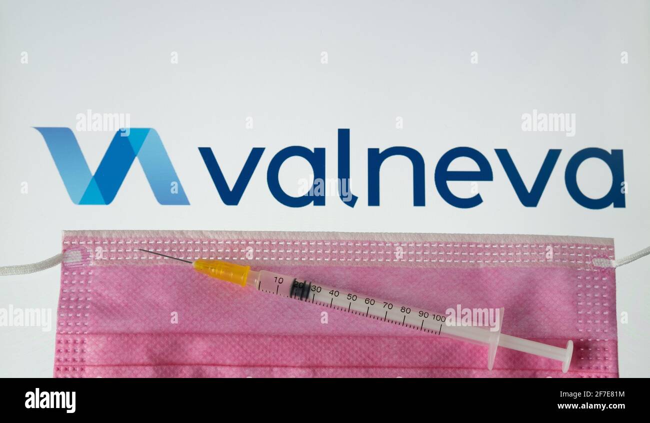 Valneva COVID-19 Impfstoffkonzept. Spritze, Gesichtsmaske und Valneva Firmenlogo auf dem unscharfen Hintergrundbildschirm. Stafford, Großbritannien, 6. April 202 Stockfoto