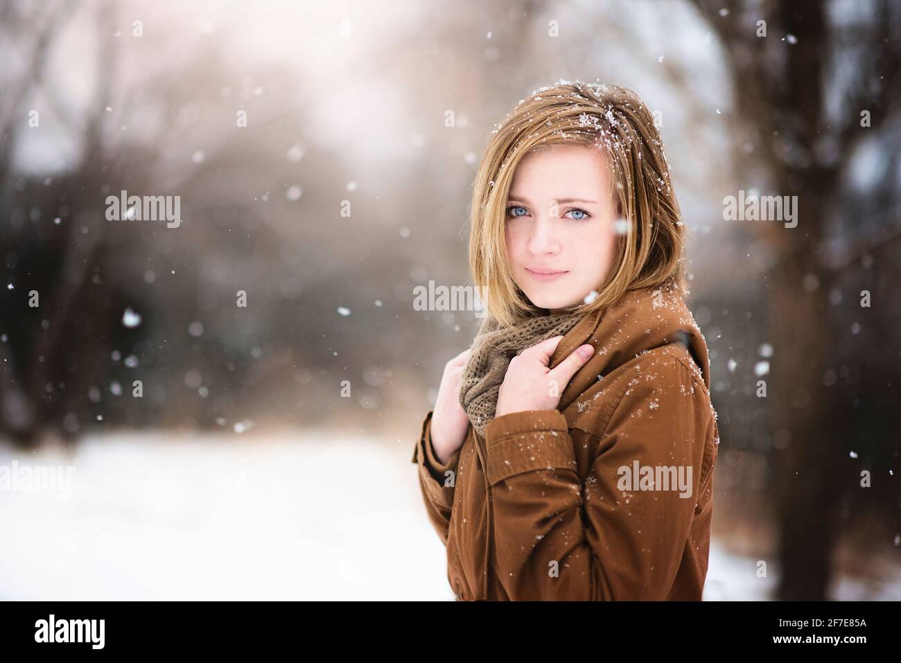 Schöne blonde Teenager-Mädchen im Freien im Schnee, Blick auf den Betrachter. Stockfoto