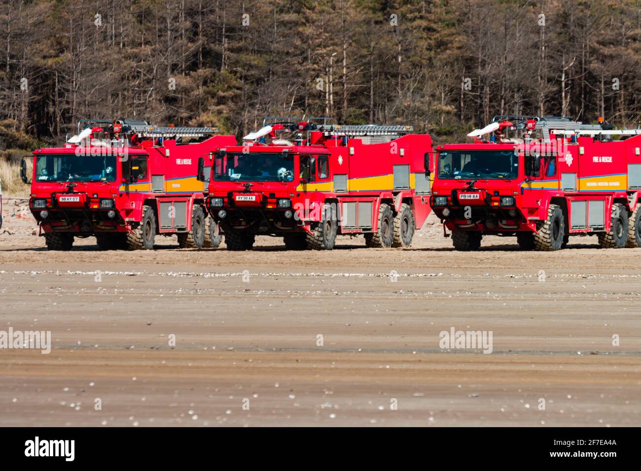 CEFN SIDAN, WALES - MÄRZ 25 2021: Mehrere Flughafen-Feuerwehrautos bieten Sicherheitsschutz für die Royal Air Force, die taktische Strandlandungen praktiziert Stockfoto