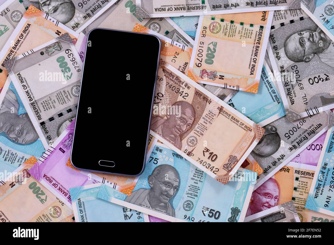 Mobiles Smartphone und indische Rupie-Noten, digitales Geld, Fin-Tech, Geld verdienen Online-Konzepte Stockfoto