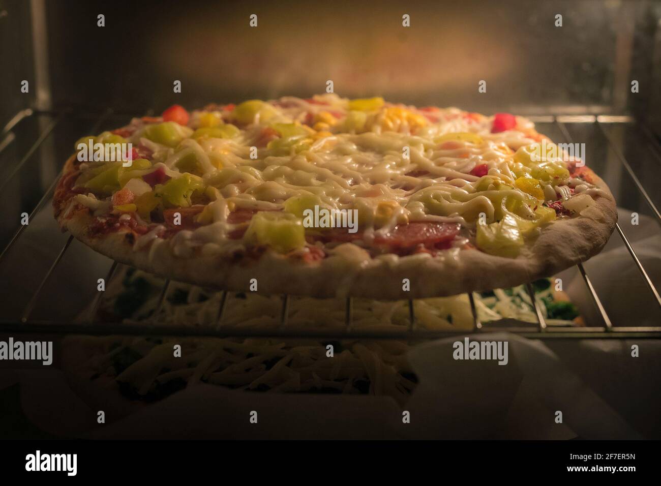 Tiefkühlpizza aus einem Supermarkt oder Geschäft wird in einem heißen  elektrischen Ofen gesehen. Zwei Pizzas im Supermarkt, die übereinander  backen Stockfotografie - Alamy