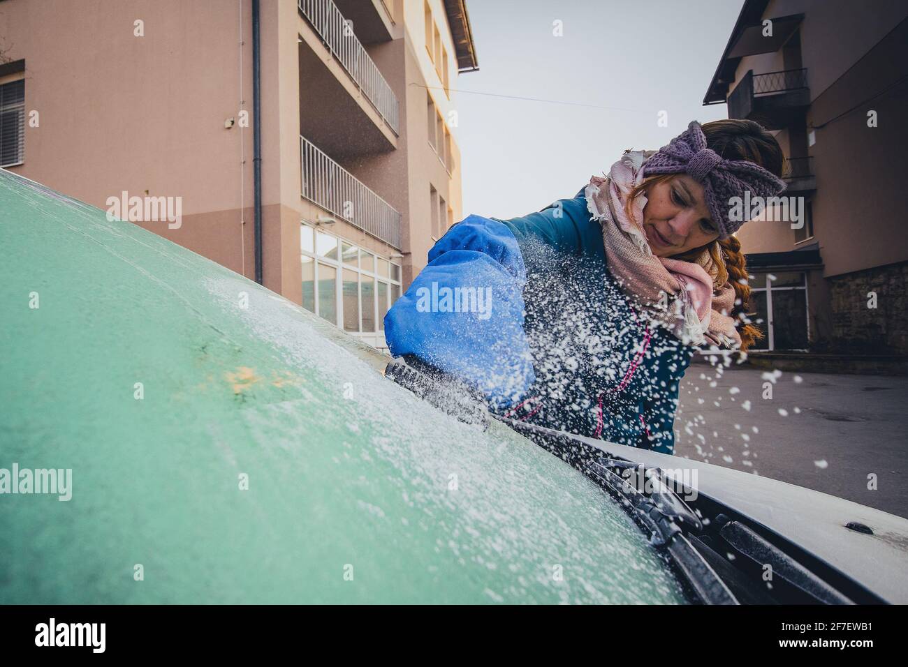 Eine Frau Putzt Schneebedeckte Fenster Auf Einem Auto Mit