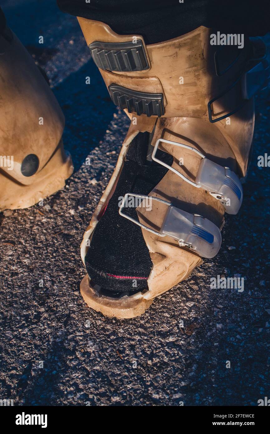 Zerstörter alter Skischuh mit einem Loch im Inneren. Beim Skifahren wurde altes Plastik auf einem Skischuh zerrissen, das Ergebnis eines zerstörten Skischuhs. Stockfoto