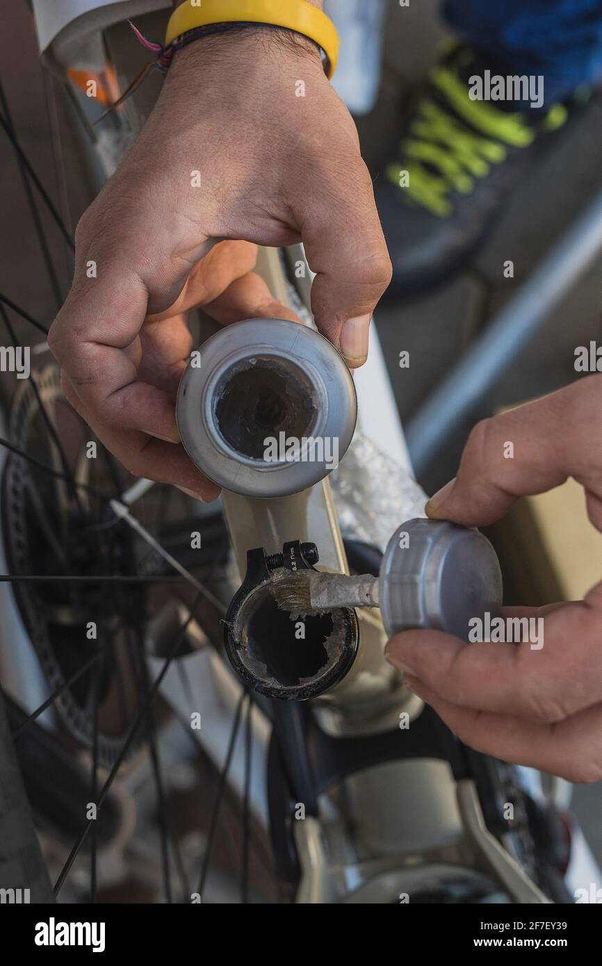 Ein inneres Sitzrohr des Fahrrads schmieren, um eine Sattelsttze zu  erhalten. Mann, der einen Fettbehlter und eine Brste hlt, um ein  Metallteil eines Mountainbikes zu schmieren Stockfotografie - Alamy