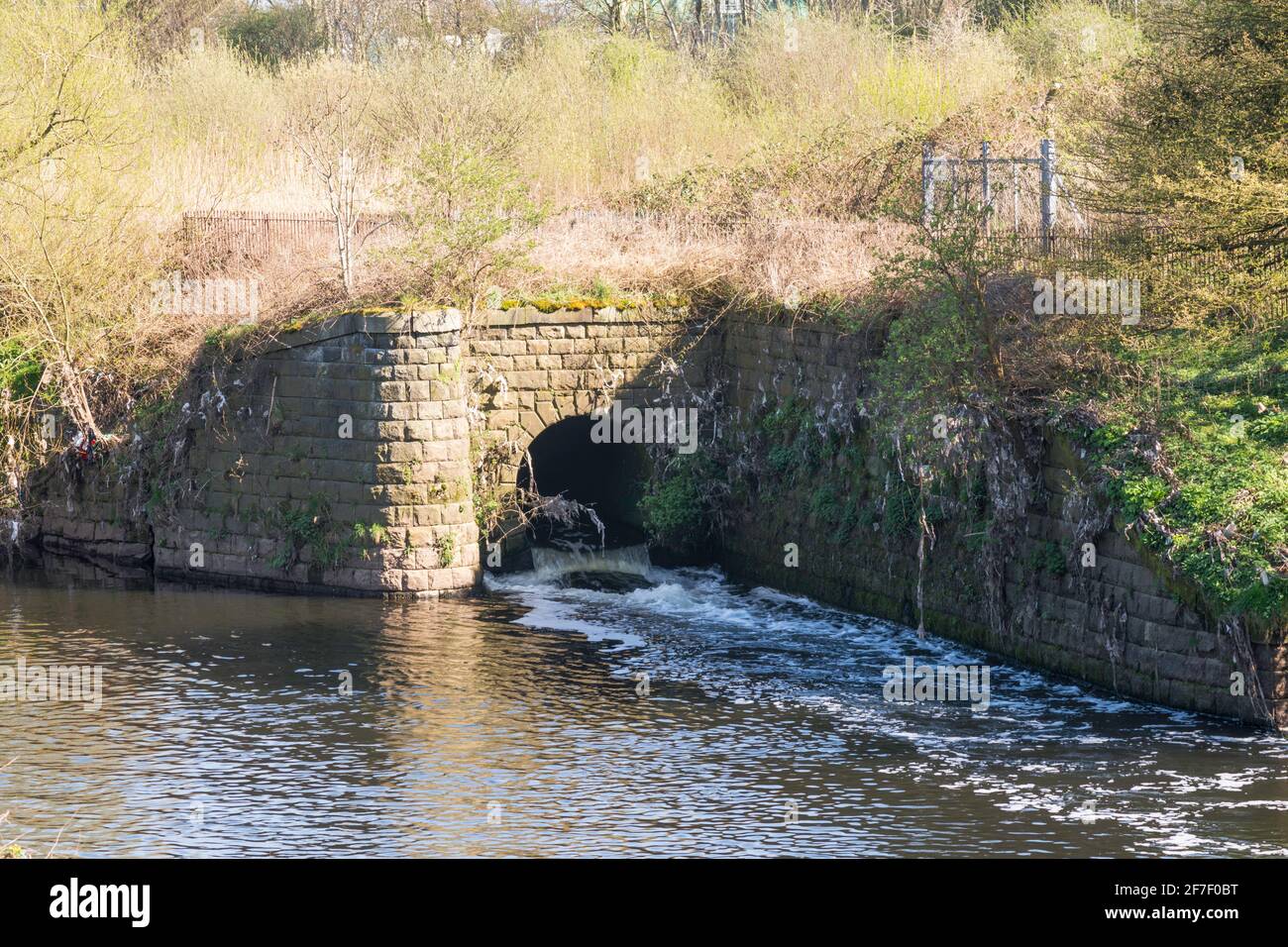 Der Fall aus einem steinernen, gewölbten, in den Fluss Mersey in Heaton Mersey, Greater Manchester, England, Großbritannien Stockfoto