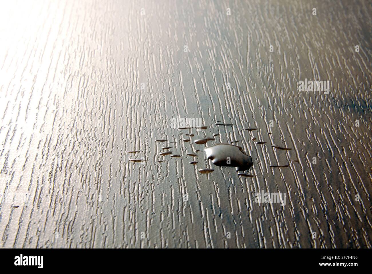 Wasser auf einen widerstandsfähigen PVC-Bodenbelag mit einem ausgelaufen Holzoptik Stockfoto