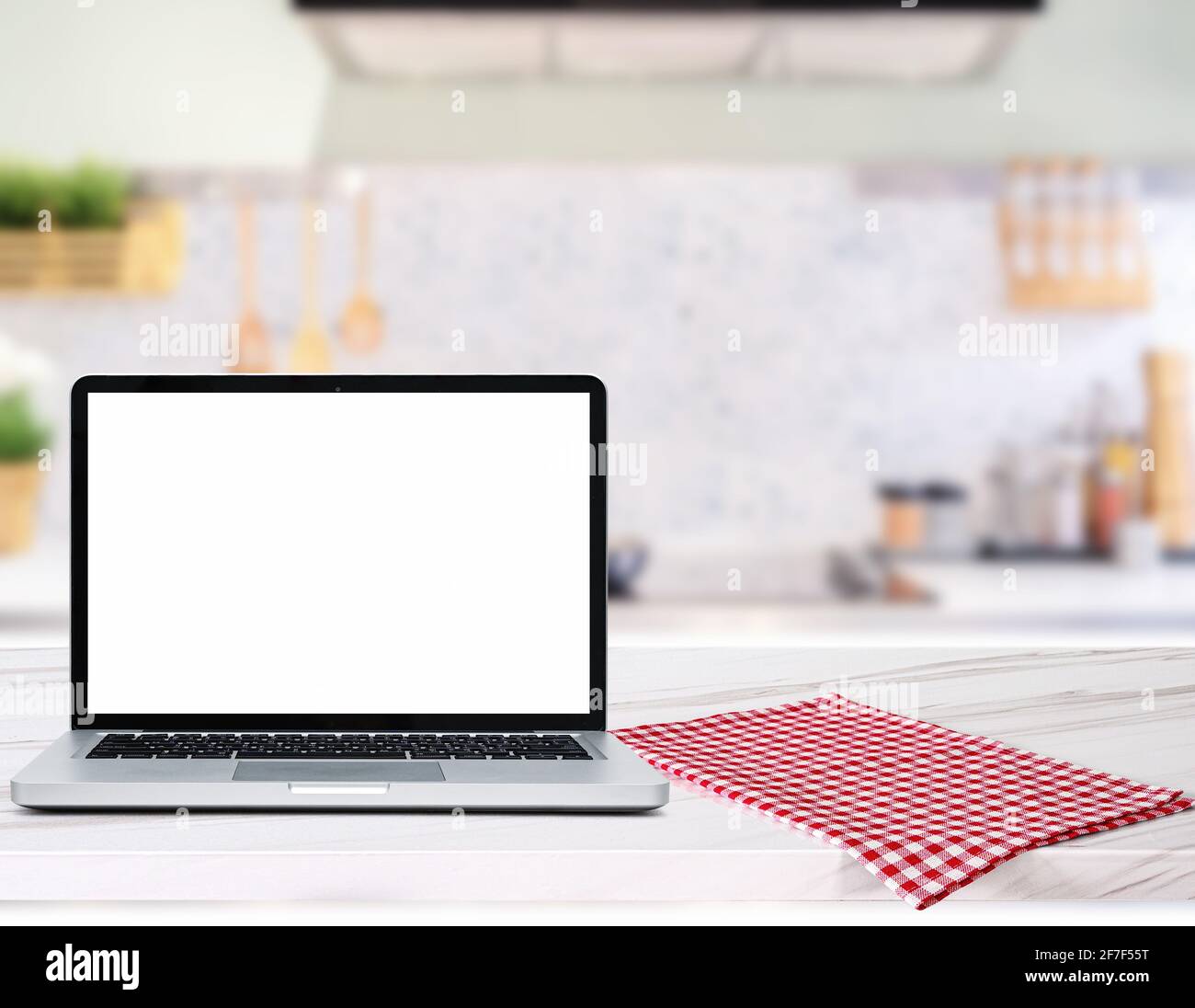 Moderner Computer, Laptop mit leerem Bildschirm auf Holztischplatte Unscharfer Küchenhintergrund Stockfoto