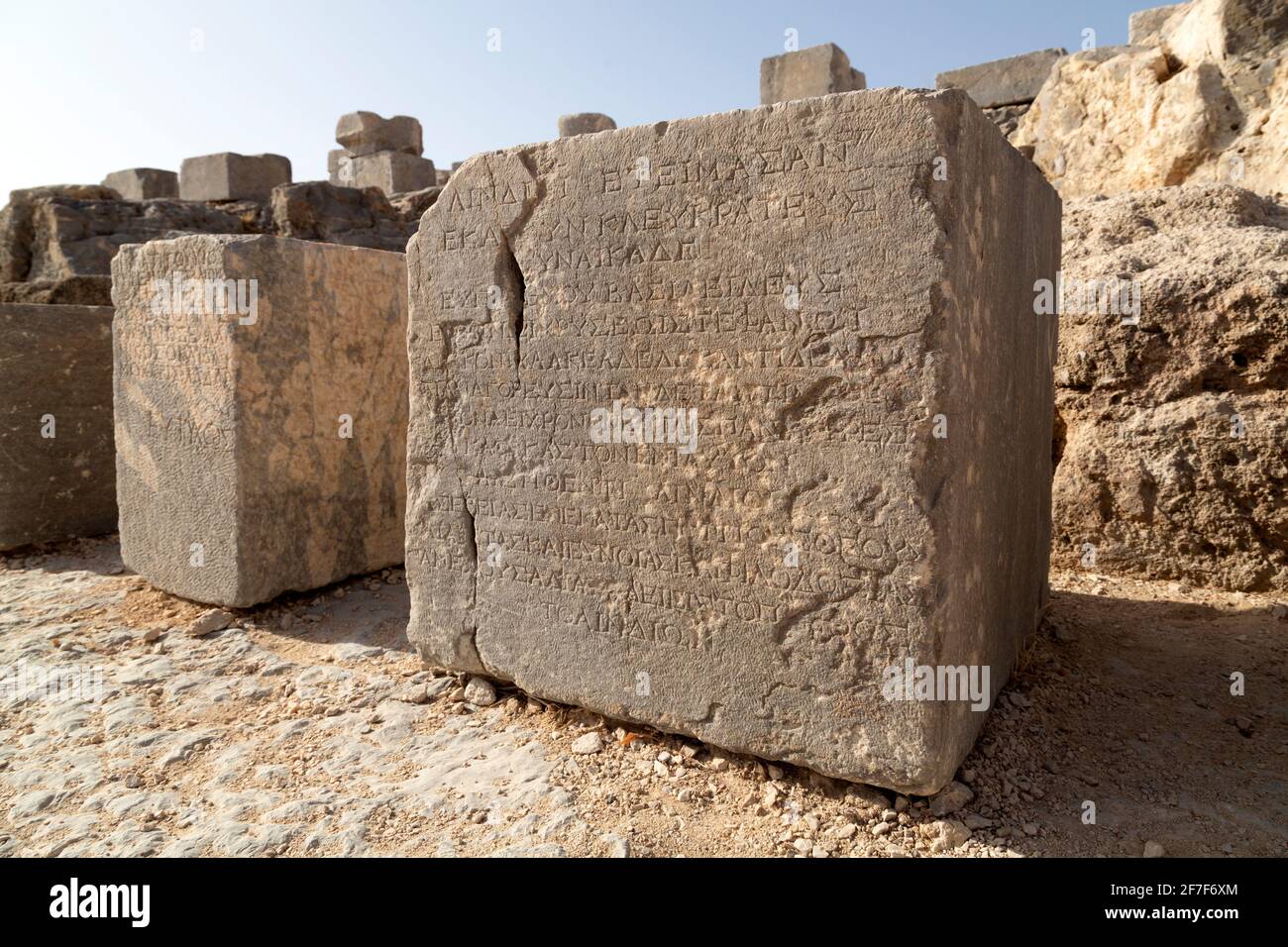 Steinblock mit griechischer Schrift auf der Lindischen Akropolis auf Rhodos, Griechenland. Die antike Stätte war früher ein Wallfahrtsort. Stockfoto