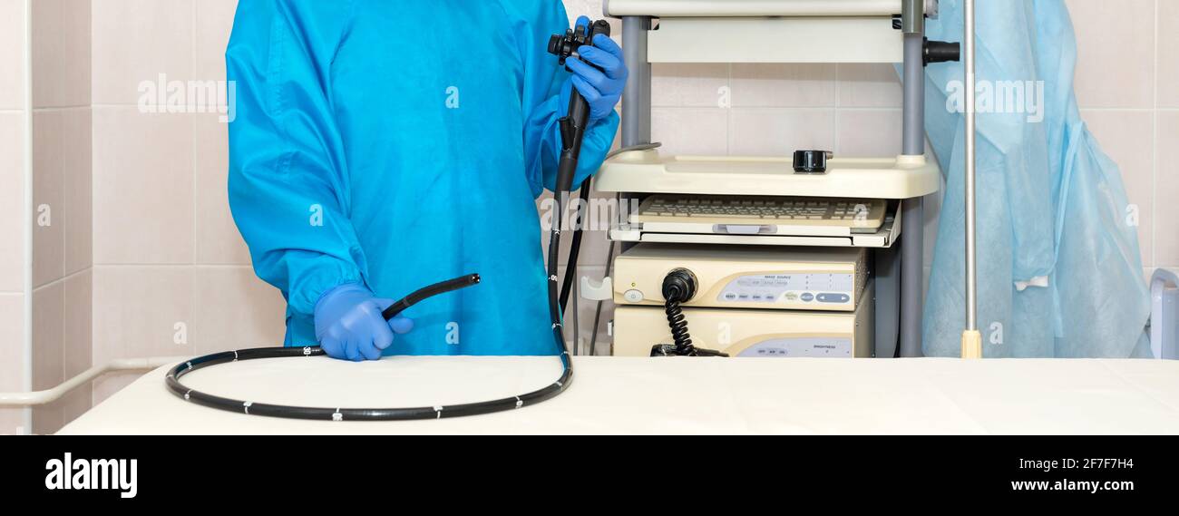 Arzt Gastroenterologe in Schutzkleidung hält Endoskop vor der Gastroskopie. Medizinische Untersuchung, medizinische Geräte und Instrumente, Gastroi Stockfoto