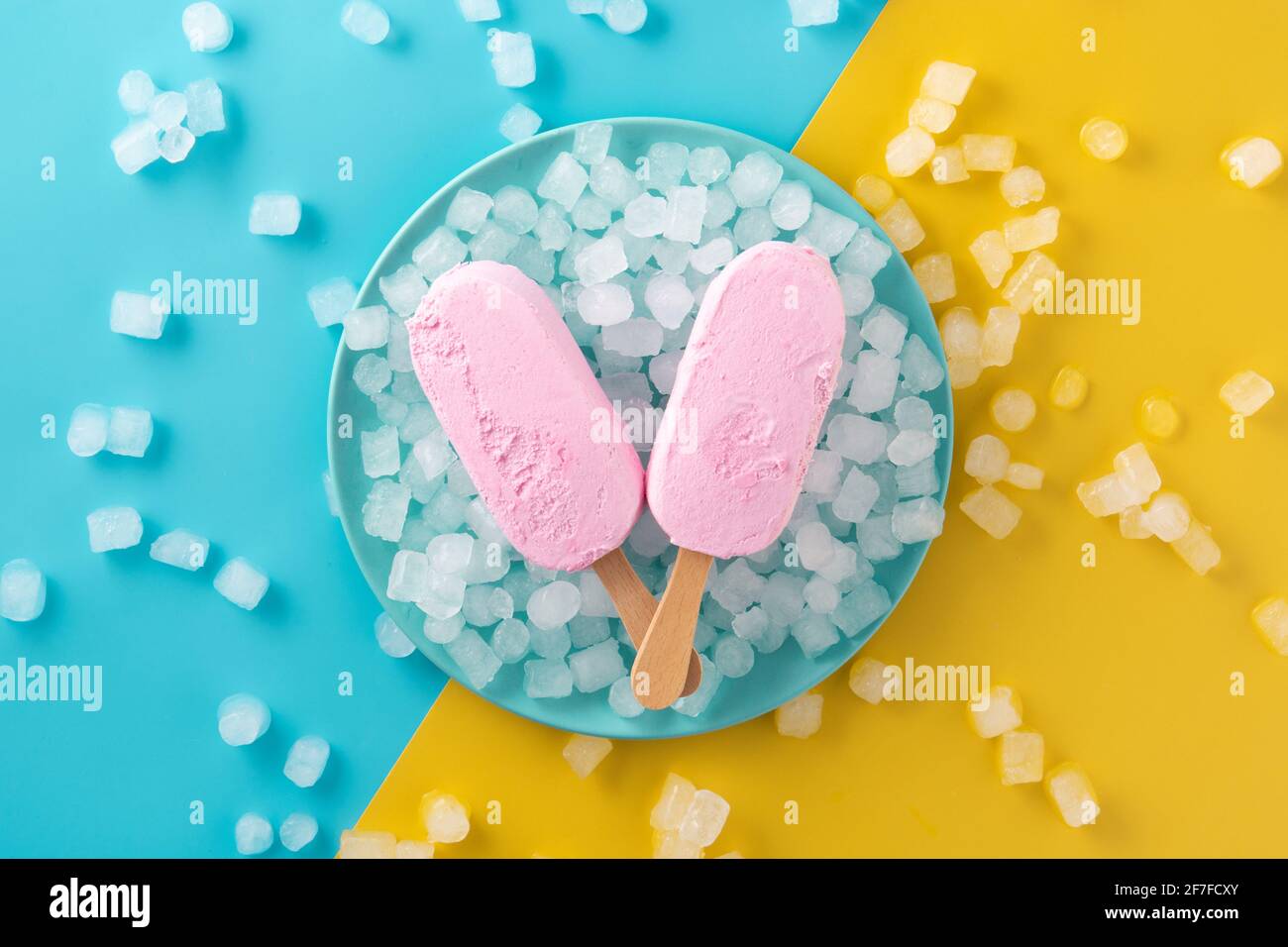 Erdbeerpopsicles und zerkleinertes Eis auf blauem Teller Stockfoto