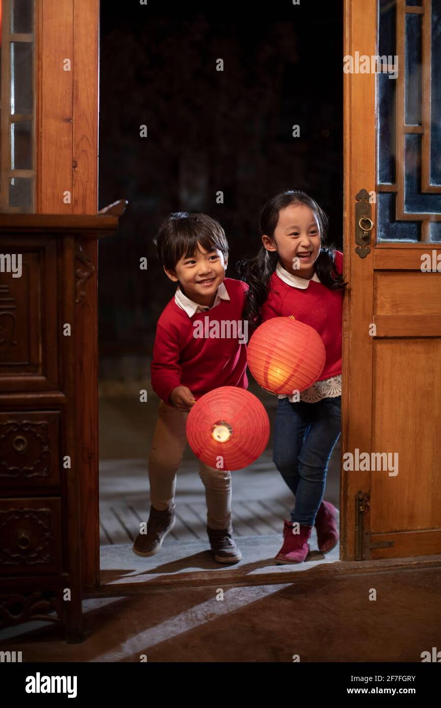 Glückliche Geschwister halten chinesische Laternen Stockfoto