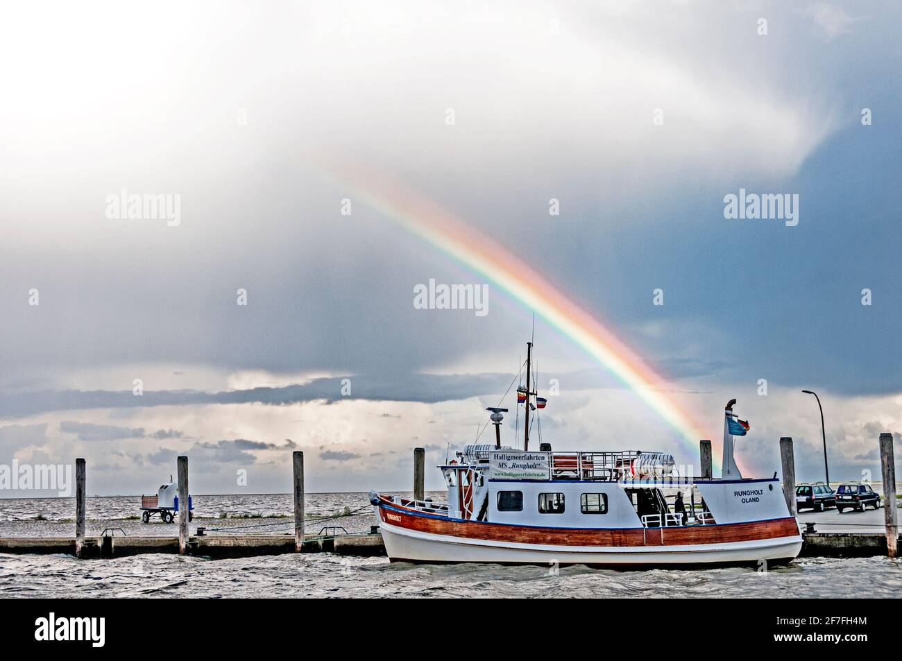 Boot in einem Hafen im Norden Deutschlands mit einem Regenbogen in den Himmel Stockfoto