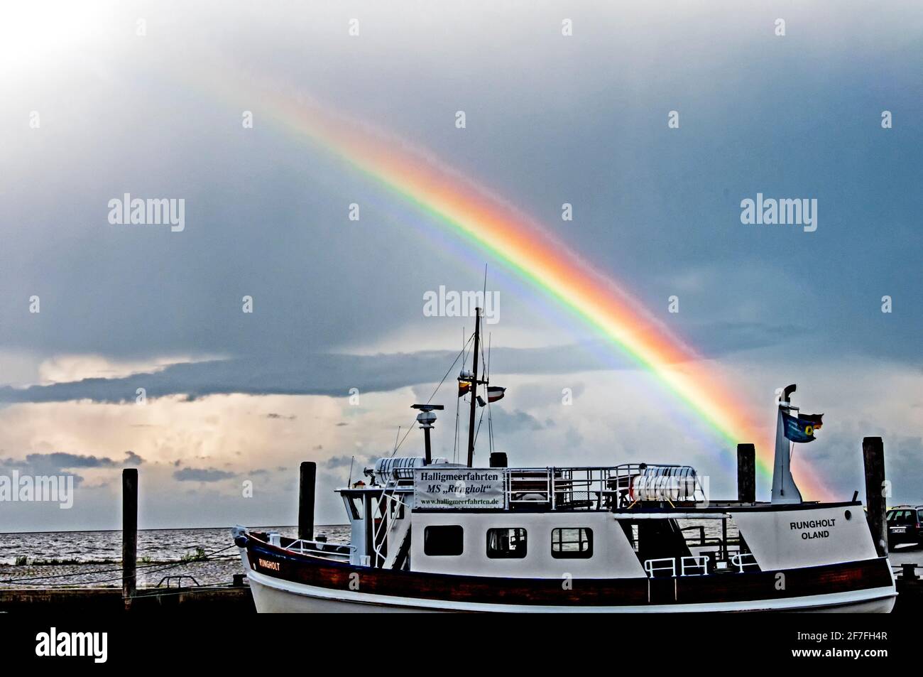 Boot in einem Hafen im Norden Deutschlands mit einem Regenbogen in den Himmel Stockfoto