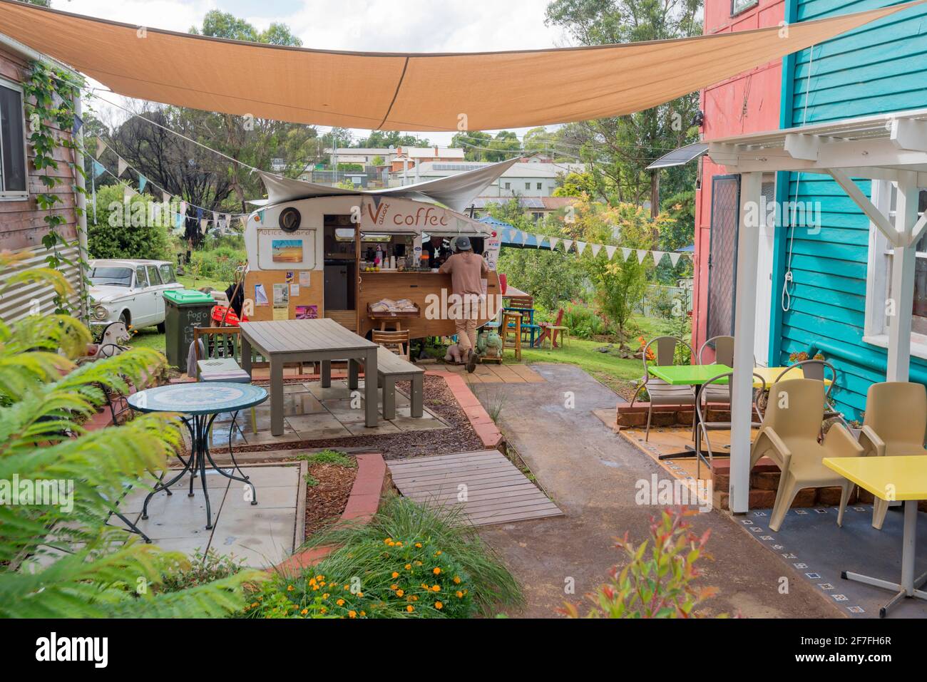 Das Valiant Coffee in Cobargo, NSW, Australien, ist in einem kleinen Holzkarawanen unterwegs und zwischen zwei Gebäuden zusammengepresst. Es serviert einen fiesen Kaffee und großartige Kuchen Stockfoto