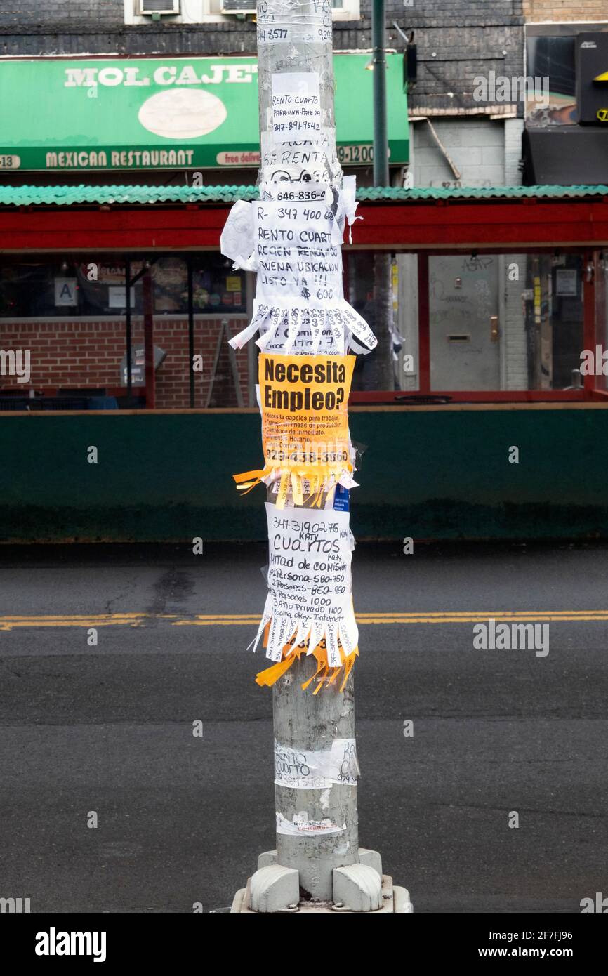 Ein Lichtmast in Jackson Heights, Queens, mit Tear-Away-Anzeigen, hauptsächlich für Wohnungsvermietungen. Stockfoto