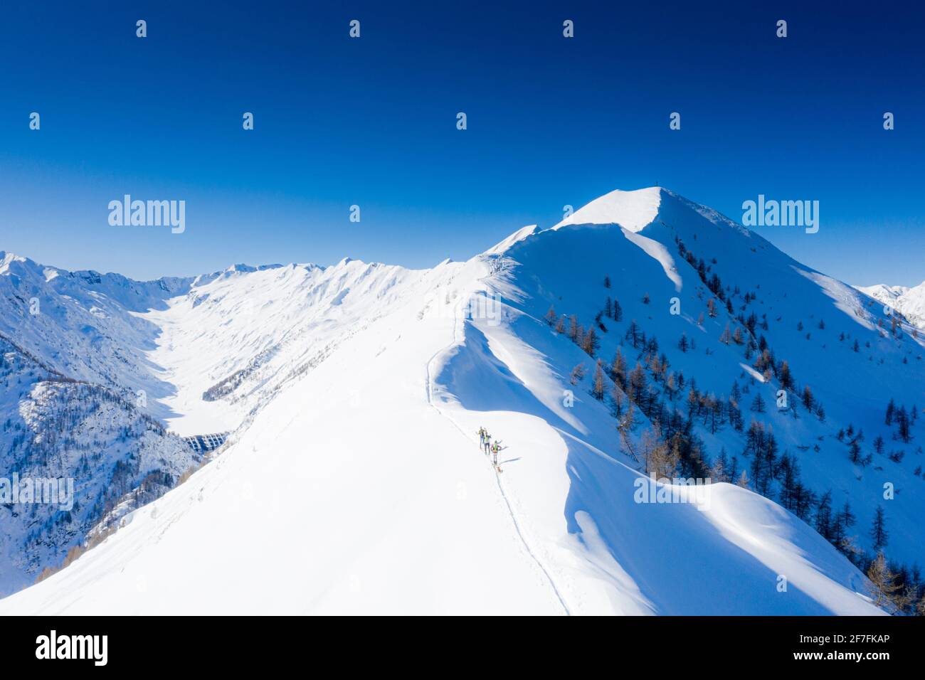 Skifahrer klettern Pizzo Meriggio mit Skiern im Winter, Valtellina, Lombardei, Italien, Europa Stockfoto