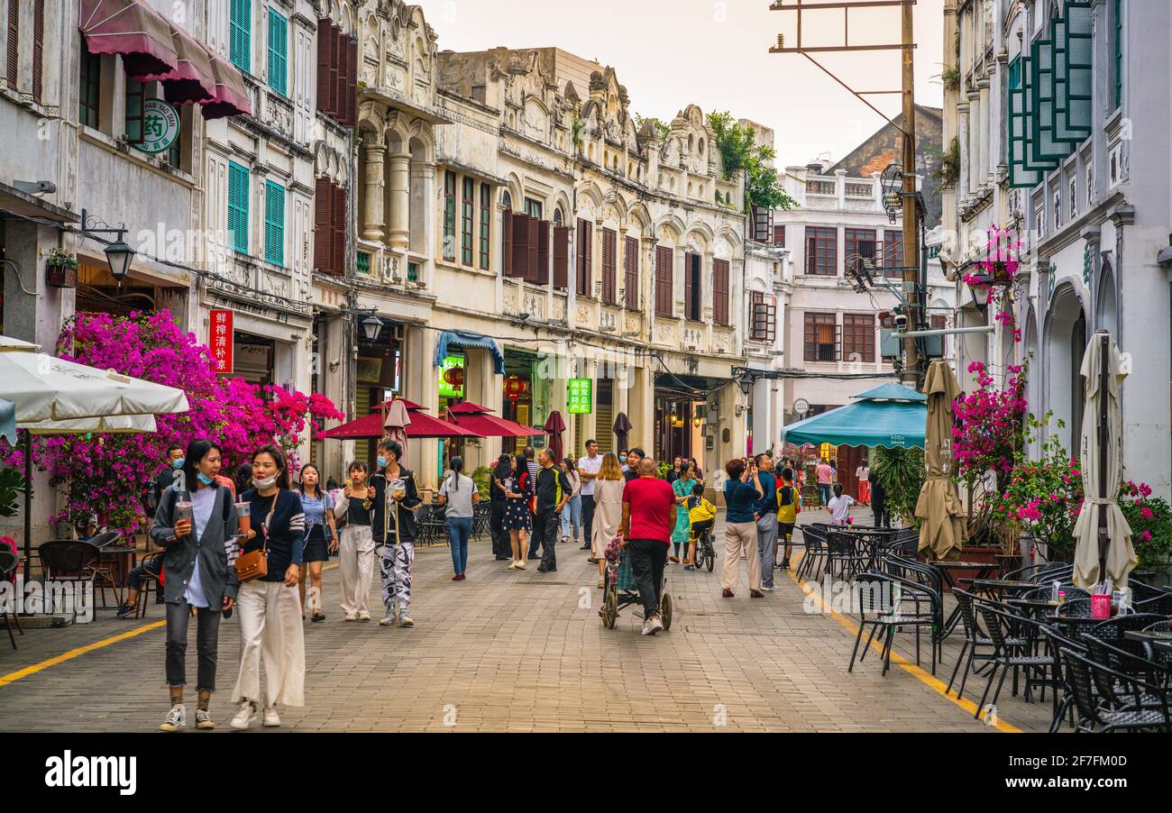 Haikou China , 21 March 2021 : Qilou alte Straße Blick auf eine Fußgängerzone mit Arcade-Gebäude mit Touristen und dramatisches Licht in Zhongshan Haikou alt Stockfoto