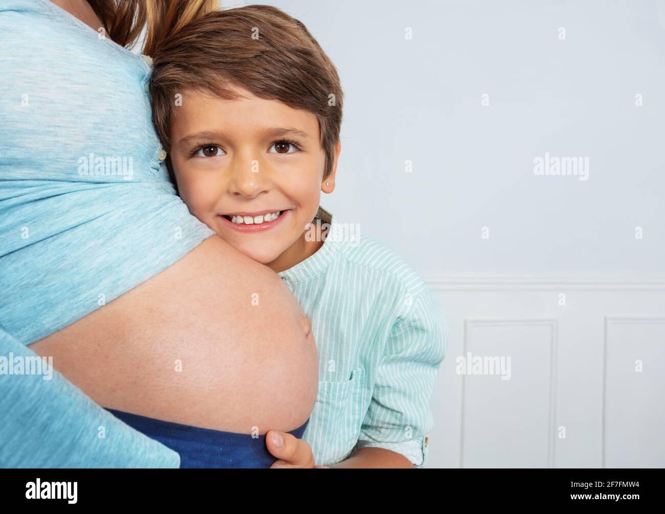 Glücklicher Sohn umarmt Mutter schwanger Bauch schließen Foto Stockfoto