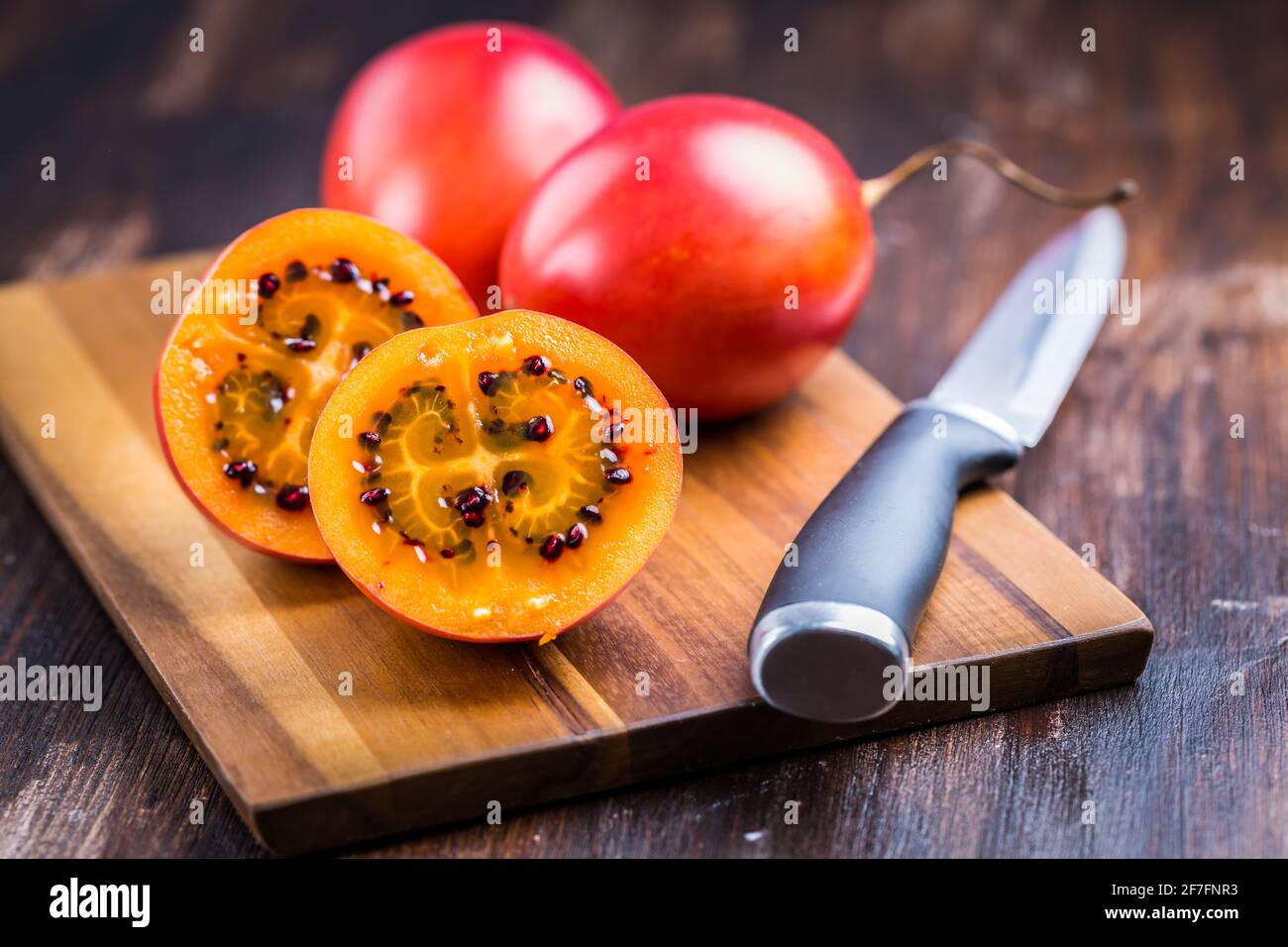 Bio-Tamarillo (Baumtomate, Solanum betaceum) auf Schneidebrett Stockfoto