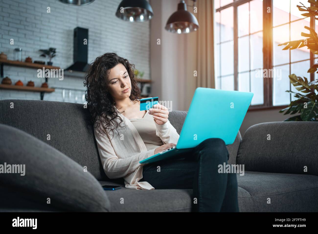 Junge Frauen machen Online-Kauf mit Kreditkarte und Laptop Auf dem Sofa zu Hause Stockfoto