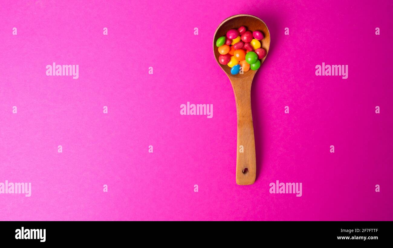 Mehrfarbiges Bonbon-Set mit einem Holzlöffel Stockfoto