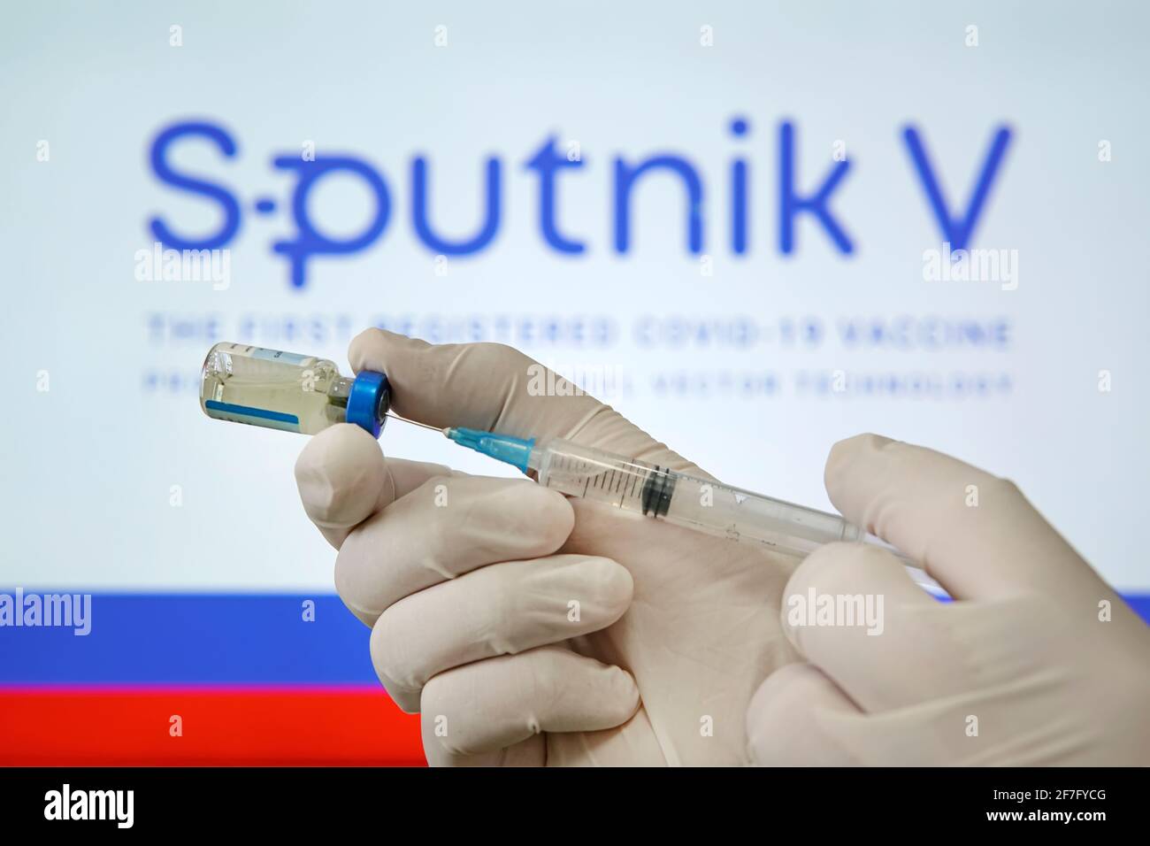 Ein Arzt bereitet einen Impfstoff gegen das Coronavirus covid 19 auf dem Hintergrund des Sputnik V-Logos vor. 18. Januar 2021, Barnaul, Russland. Stockfoto