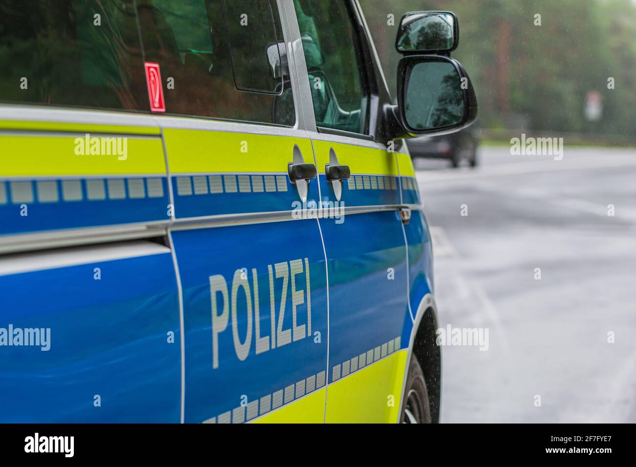 Polizeiauto von der Seite. Beifahrerseite mit Türen und Schriftzug Police auf der Karosserie. Fenstergehäuse von der Beifahrerseite mit Gelb und Blau spiegeln Stockfoto