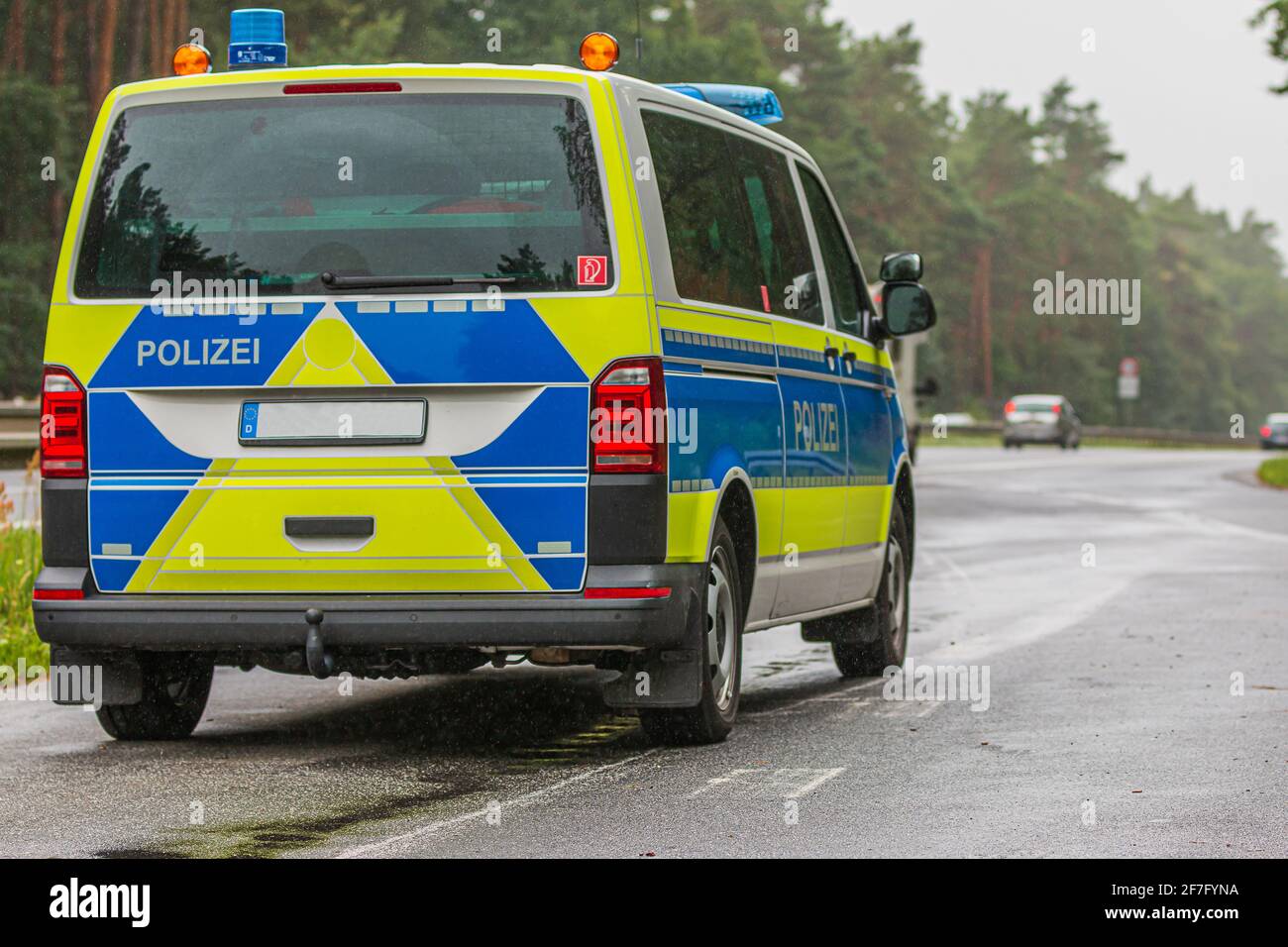 Polizeiauto in einem Notstopp neben der Autobahn aus dem Land Brandenburg.  Polizeifahrzeug in blau-gelber Lackierung mit reflektierenden Streifen  Stockfotografie - Alamy