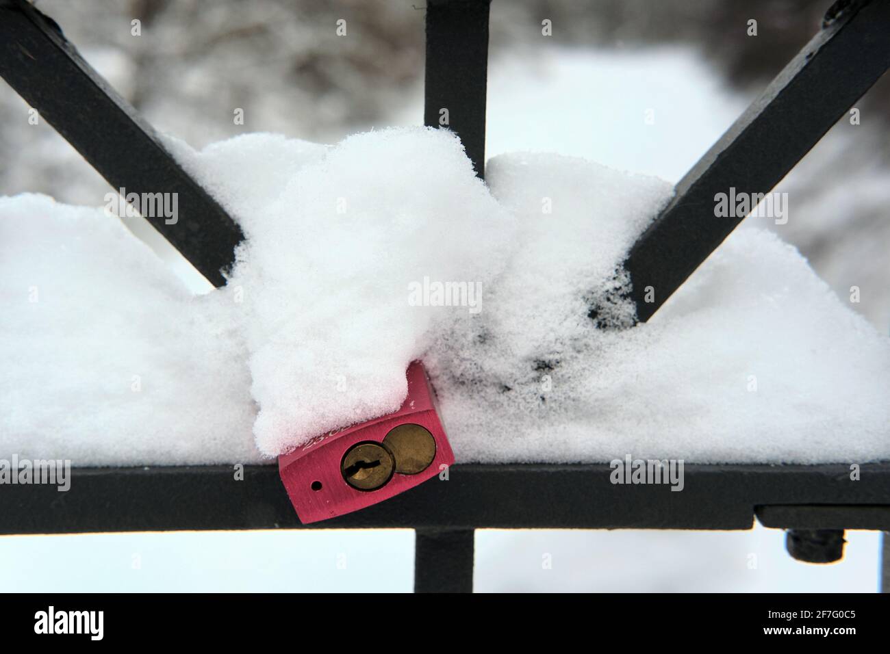 Braunschweig, Deutschland. Februar 2021. An der schneebedeckten Brücke über den gefrorenen Oker River unterhalb von Richmond Castle hängt ein sogenanntes Liebesschloss in Rot. Die Niedersachsen werden bis zum nächsten Wochenende die weiße Pracht genießen, bevor es wieder wärmer wird. Quelle: Stefan Jaitner/dpa/Alamy Live News Stockfoto