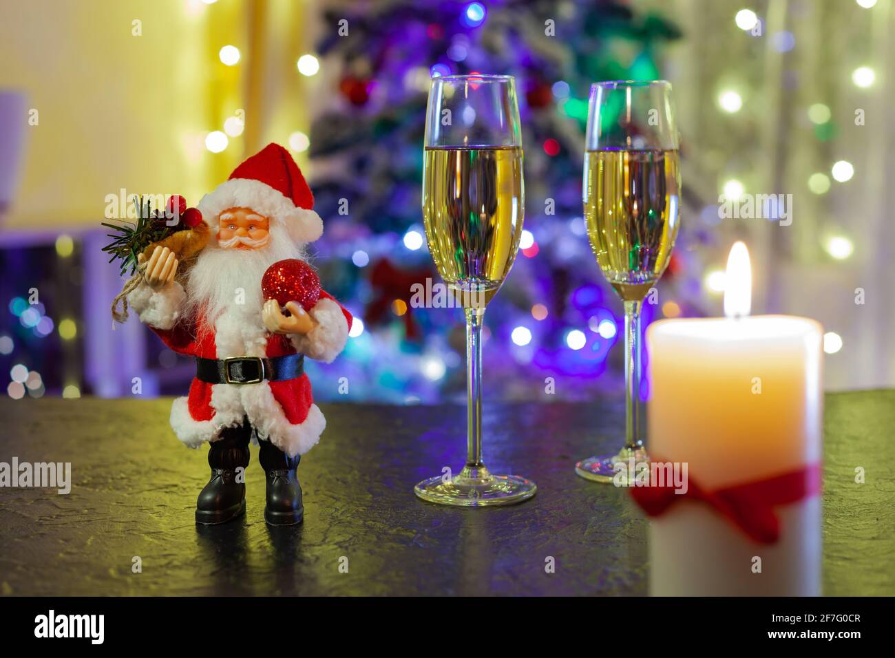 Der Weihnachtsmann und zwei Gläser Champagner auf dem schwarzen Tabelle Stockfoto