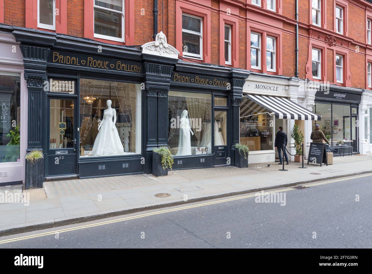 The Bridal Rogue Gallery Wedding Dress Shop und Monocle Cafe. Zwei Personen stehen auf der Straße vor dem Café. Chiltern Street, London, England, Großbritannien Stockfoto