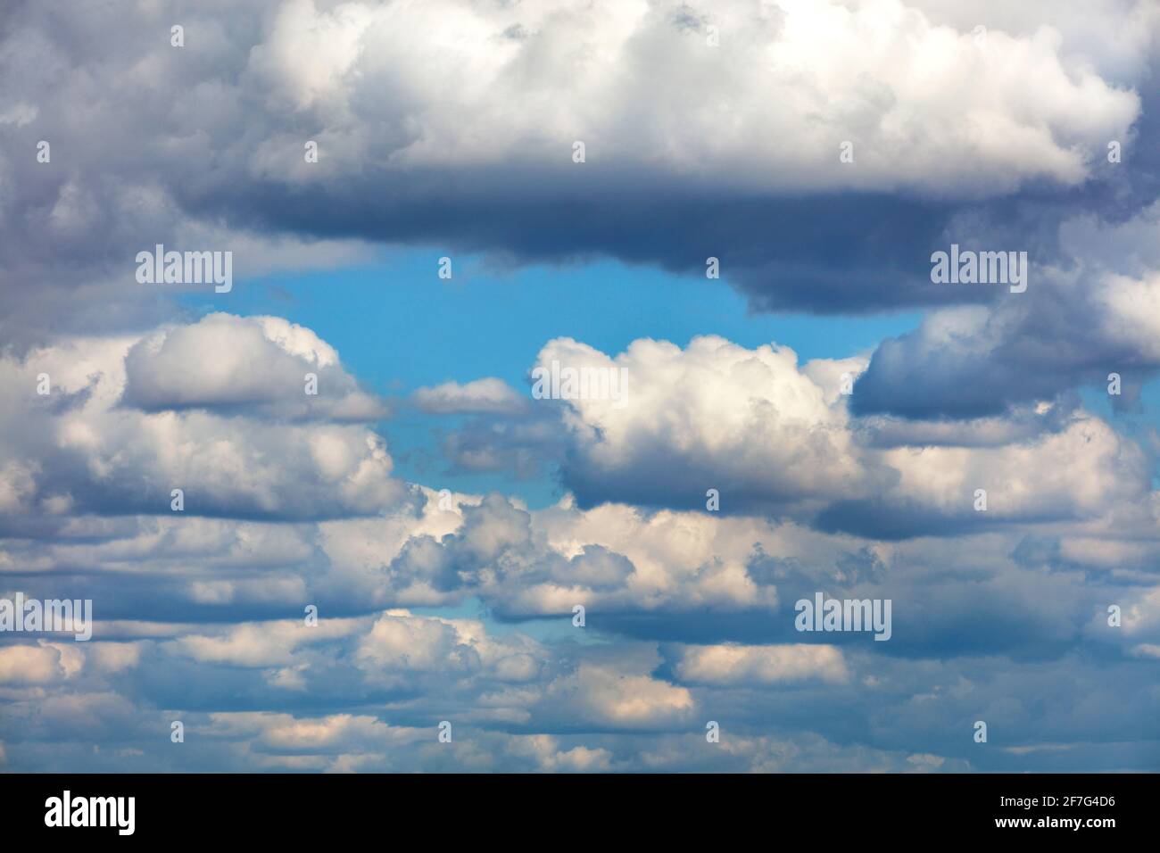 Weiche, verdickende Wolken sammeln sich in grauen Massen und blockieren allmählich den blauen Himmel. Speicherplatz kopieren. Stockfoto