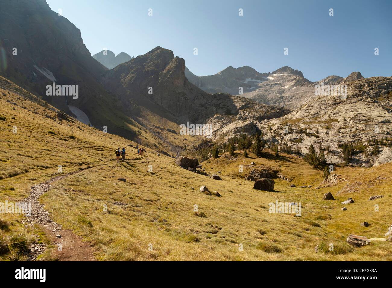 Landschaftsfotografie der einsamen Berge im Sommer, unter einem riesigen blauen Himmel, während eine Gruppe von Wanderern in der Ferne zu Fuß, Aragonische Pyrenäen, Hu Stockfoto