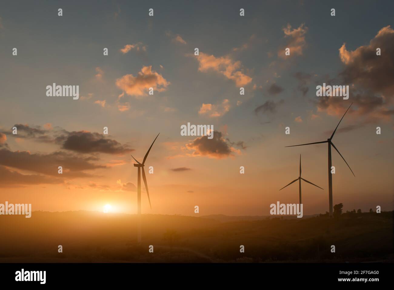 Silhouette von Windenergieanlagen. Schöne Sicht auf Windgeneratoren im Berghügel bei Sonnenuntergang. Stockfoto