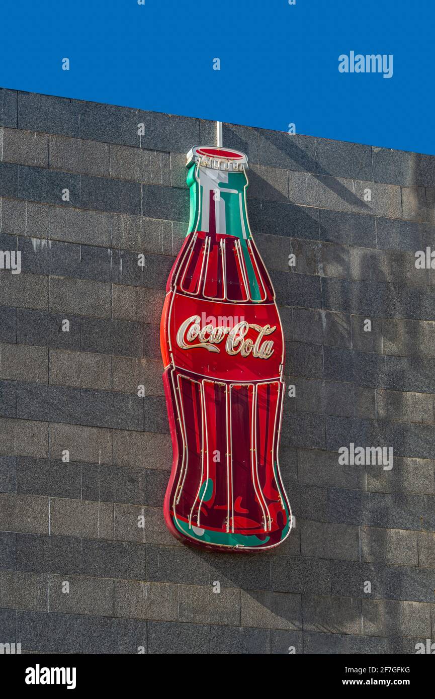 Große Coca-Cola-Flasche aus Neon an einer Wand. Branding-Werbung. Stockfoto