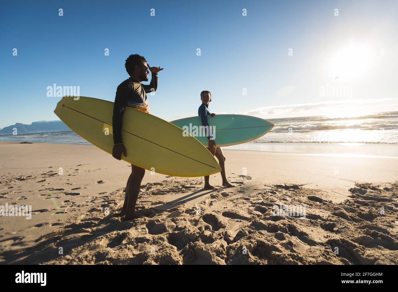 Glückliches afroamerikanisches Paar am Strand mit Surfbrettern Stockfoto