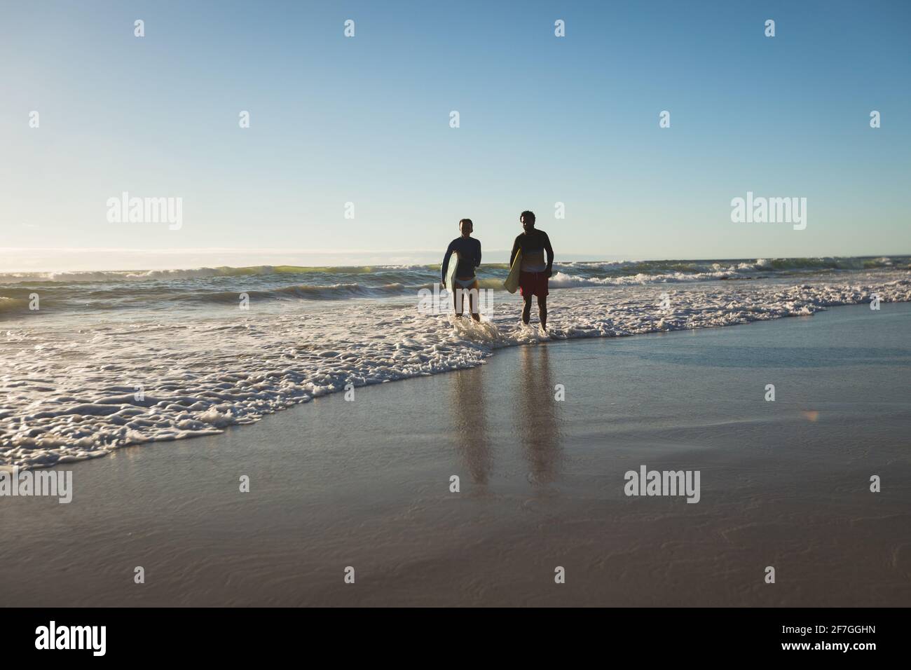 Glückliches afroamerikanisches Paar mit Surfbrettern am Strand Stockfoto